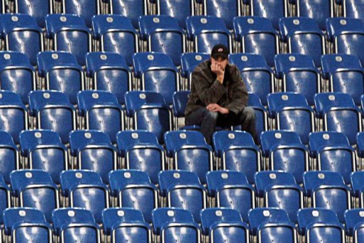 man-sitting-alone-in-empty-stadium